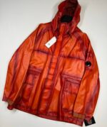 CP COMPANY 129A BI-FILM PARKA LENS JACKET IN PUMPKIN ORANGE